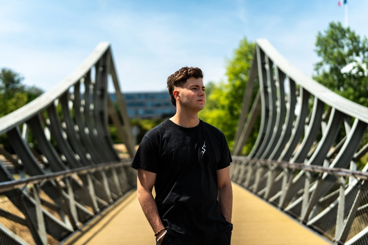 Sykra sur une passerelle, entouré de lignes architecturales